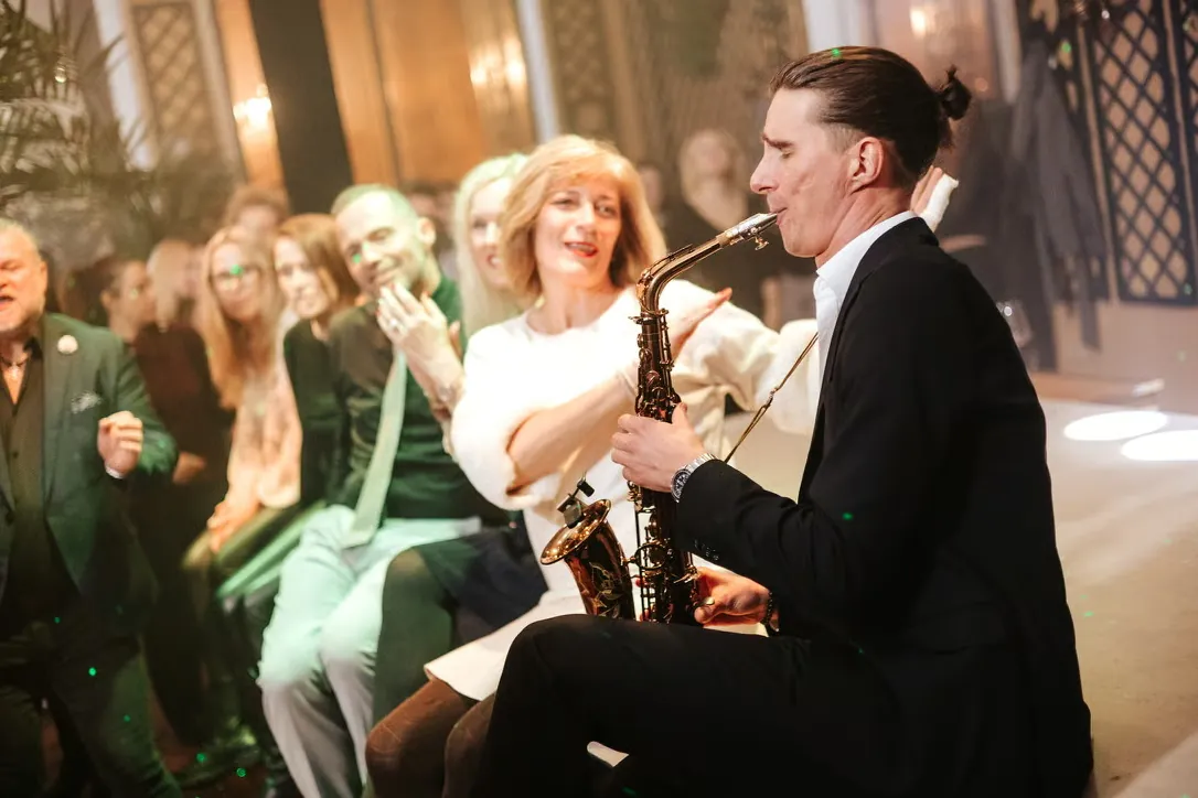 Saxophonist spielt mitten unter den Gästen bei einem Dinner im Palais